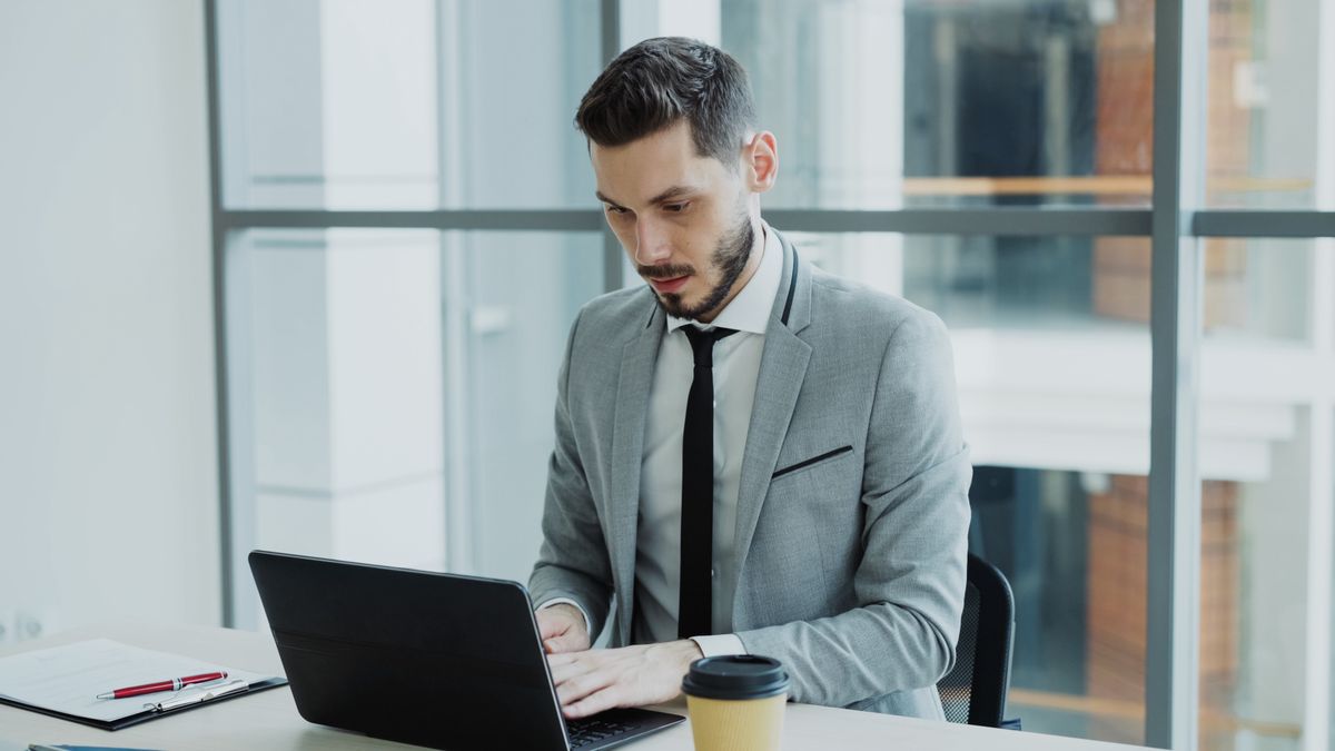 Un dirigeant au travail sur son ordinateur portable, dans un bureau lumineux